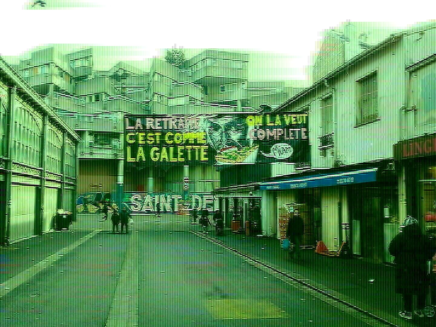 une bannière suspendue à Saint Denis contre la réforme des retraites, qui dit : "la retraite c'est comme la galette, on l'a veut complète"