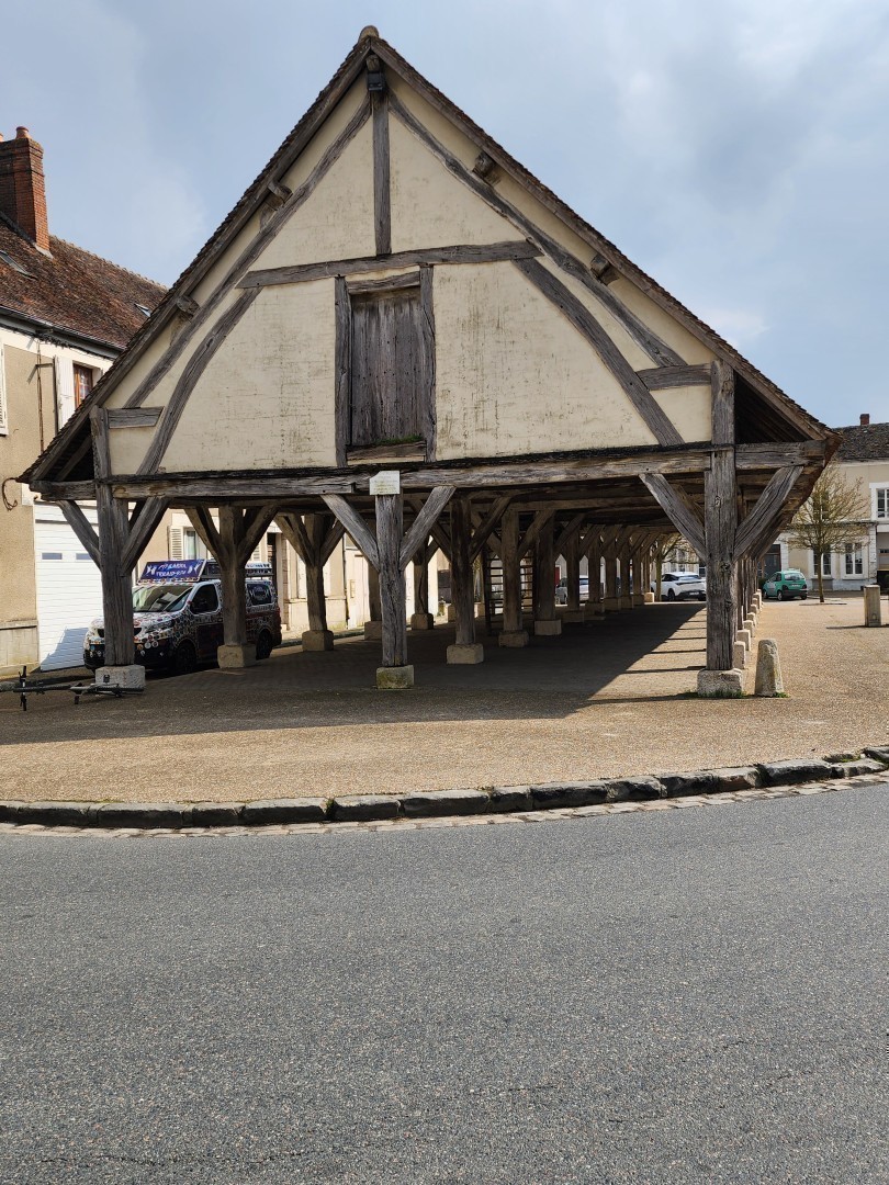 Viue d'ensemble d'un grenier à grain communal formé d'un toit pointu d'environ 5 mètres de haut et soutenu par 3 rangées de 12 piliers de bois chacun renforcé en haut par 2 pièces de bois formant des angles de 45 degrés