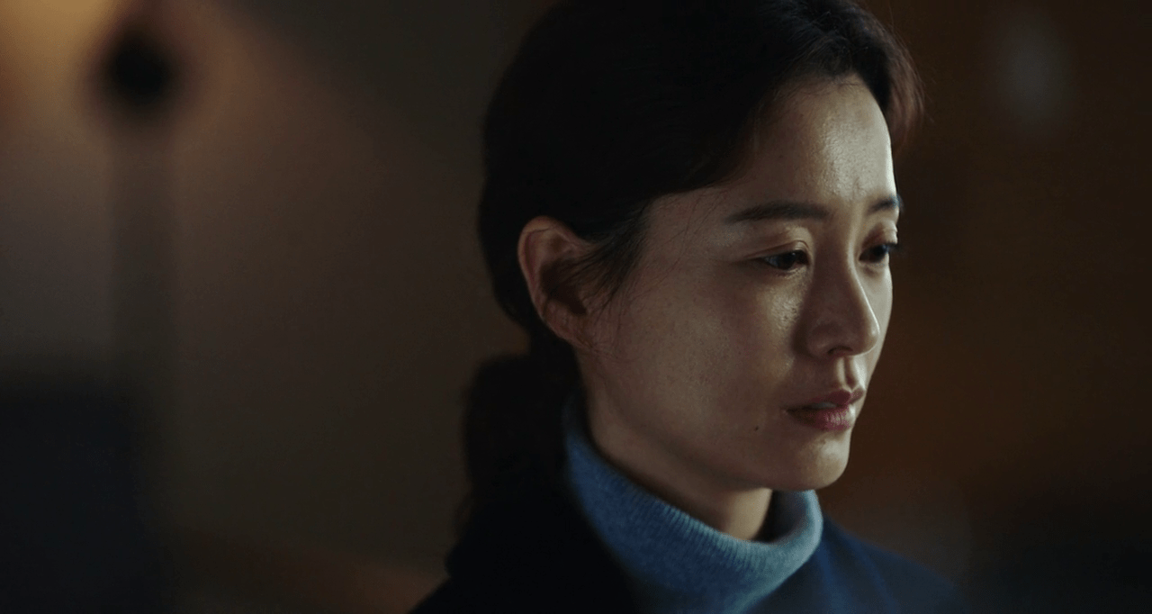 L'actrice Jung Yu-mi, pensive, regarde sur la droite. Le reste de l'image est flou