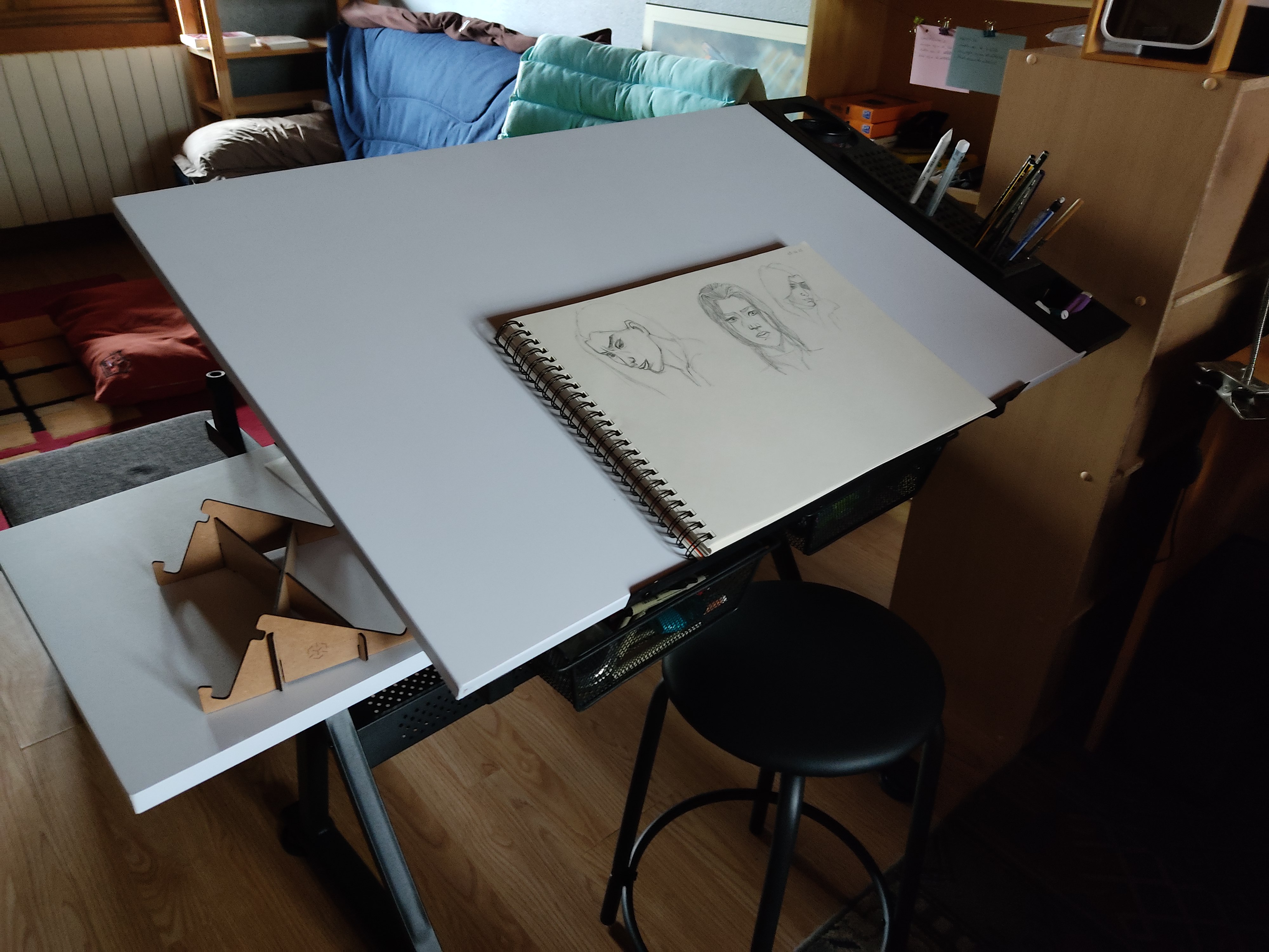 Photo d'une table à dessin avec un carnet de croquis posé dessus