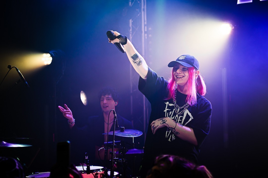 THEA tend le micro vers le public en riant