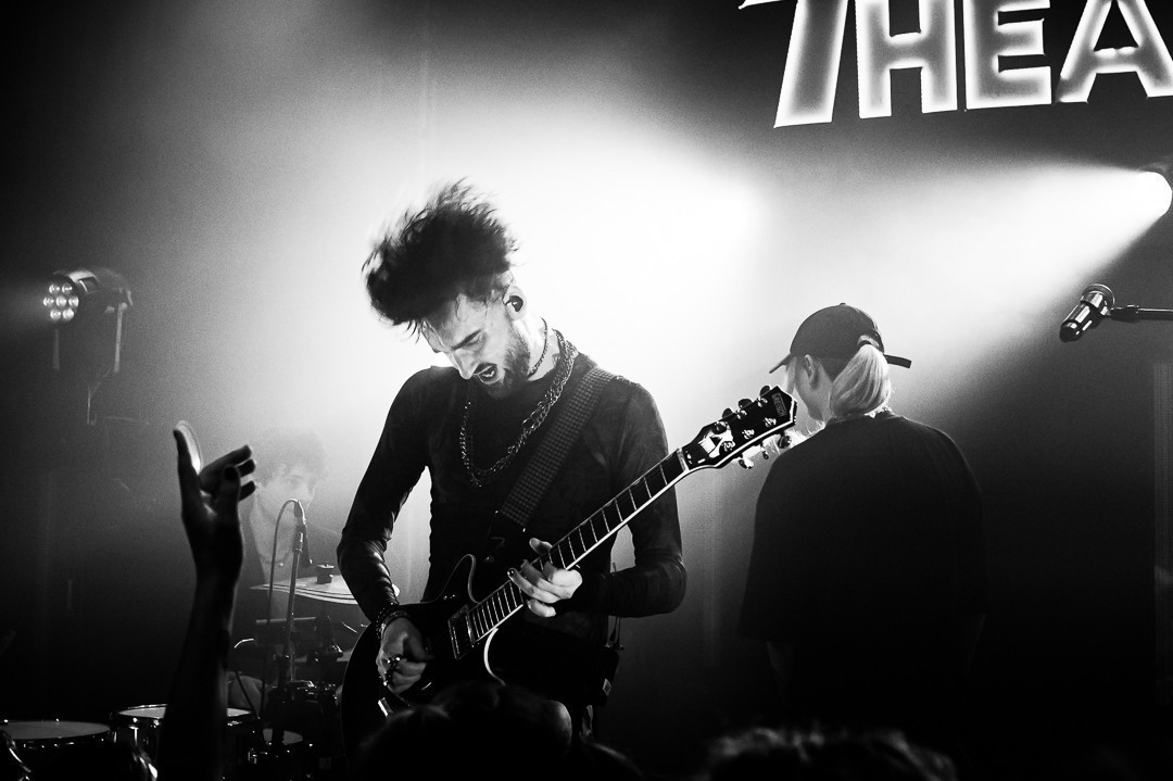 Noir et blanc, le guitariste à fond , la tête un peu flou, les cheveux qui volent