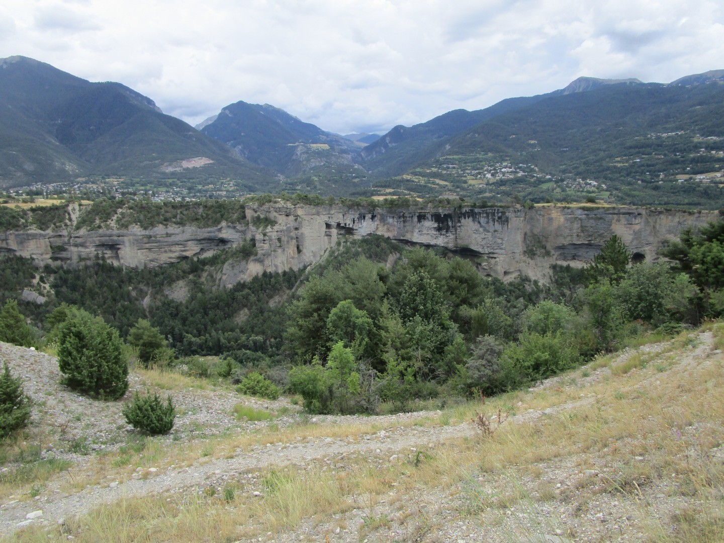 Vue sur une falaise / rebord de plateau, au milieu d’un paysage de montagne