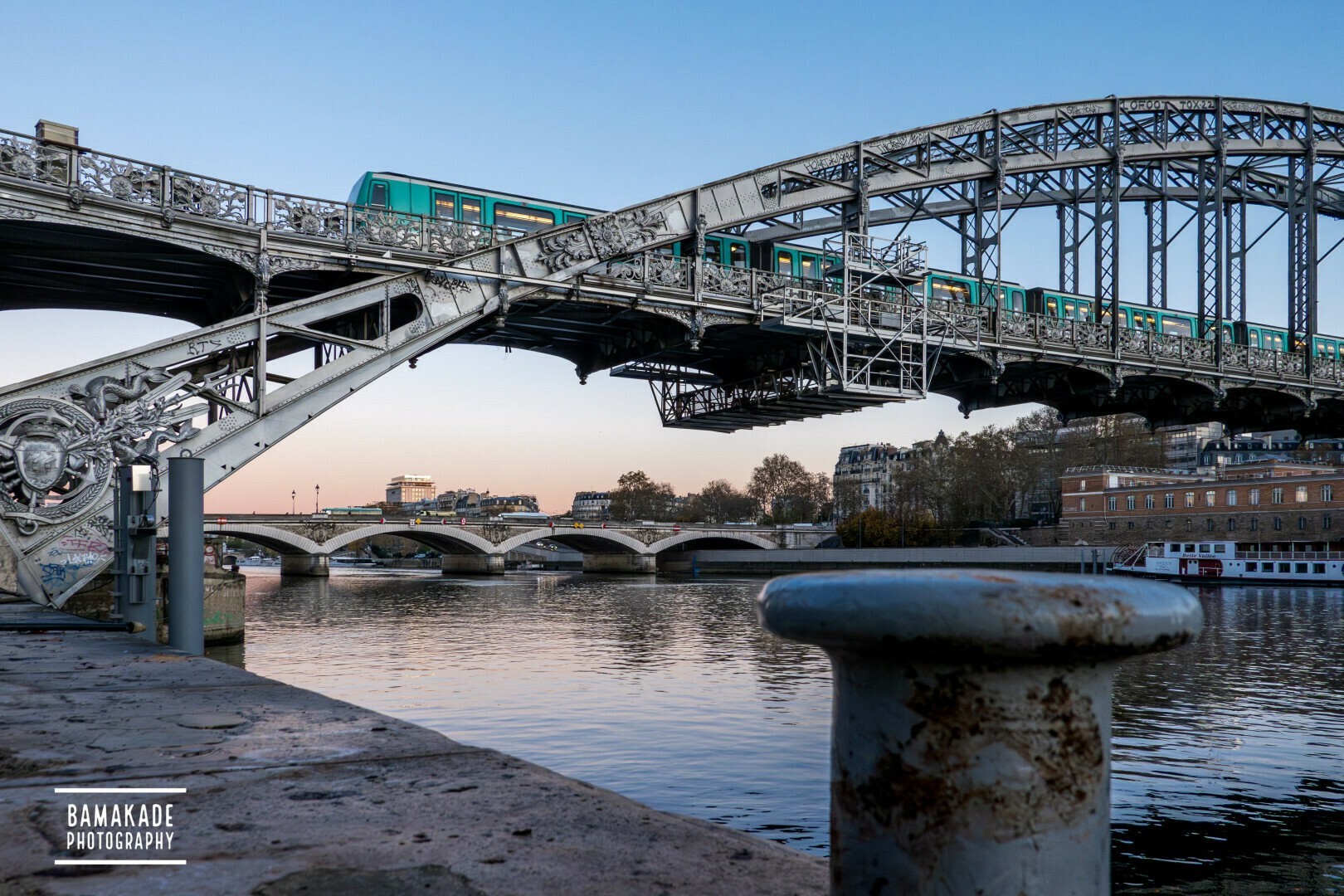 A metro is crossing a metal bridge in Paris at sunrise

Un métro traverse un pont métallique à Paris au lever du soleil