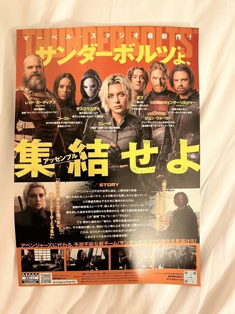 L'image montre une affiche de film en deux parties, en japonais 

En haut
Plusieurs personnages sont alignés horizontalement , chacun dans une posture distincte. Ils portent leurs costumes de super-héros. Les expressions sont sérieuses et concentrées.
Le texte est en japonais, avec des caractères jaunes vifs qui se détachent sur un fond rouge et noir. Les caractères sont grands et audacieux, indiquant le titre du film et le nom de chaque personnage avec leur définition. 

En bas
Cette section contient des images plus petites et des descriptions textuelles. Il y a des photos de scènes du film, montrant des personnages en action ou dans des moments dramatiques.
Il y a plus de texte en japonais qui résume l'intrigue, le nom des acteurs et réalisateurs.