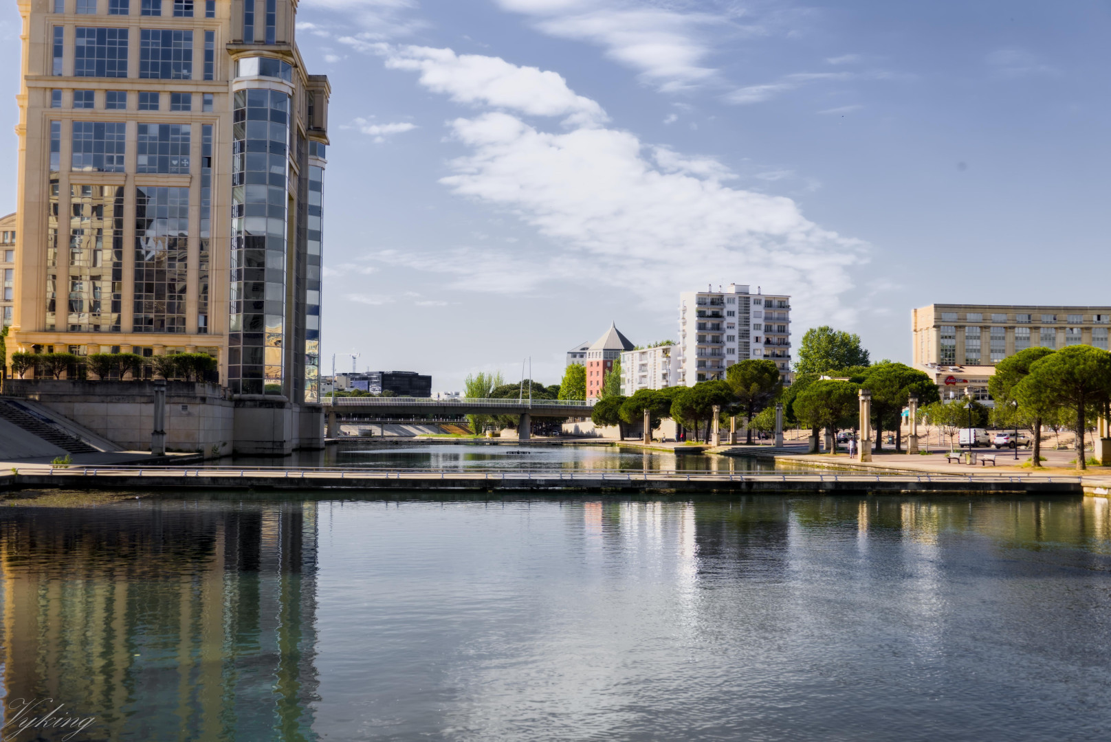 Les berges du Lez, à Montpellier, vu vers l’aval. À gauche l’hôtel de région. À droite le début du quartier Antigone. Au fond, la fac de droit. 
Deux ou trois fois par ans, lors des épisodes cévenols (fortes pluies et orages), les passerelles et la route qui longe les berges sont submergées et les rives deviennent impraticables, et dangereuses.
Mais sous le soleil, c’est l’occasion de travailler la composition et les choix de traitement des photos.