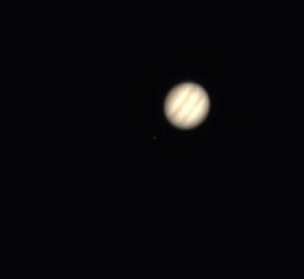 Jupiter, un peu floue, en couleur, sur fond noir, la nuit.