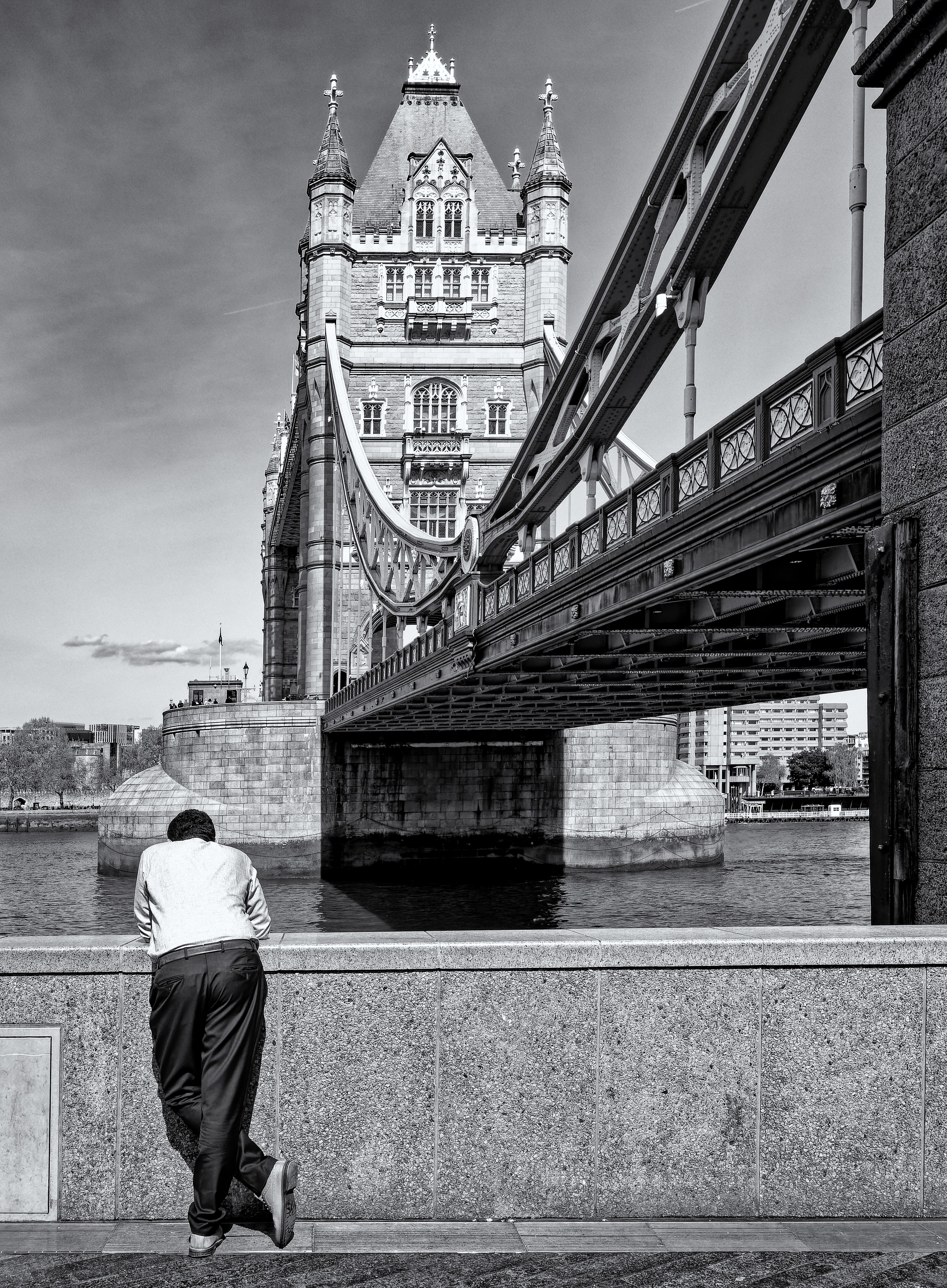 Homme qui regarde son smartphone devant le Tower Bridge de Londres