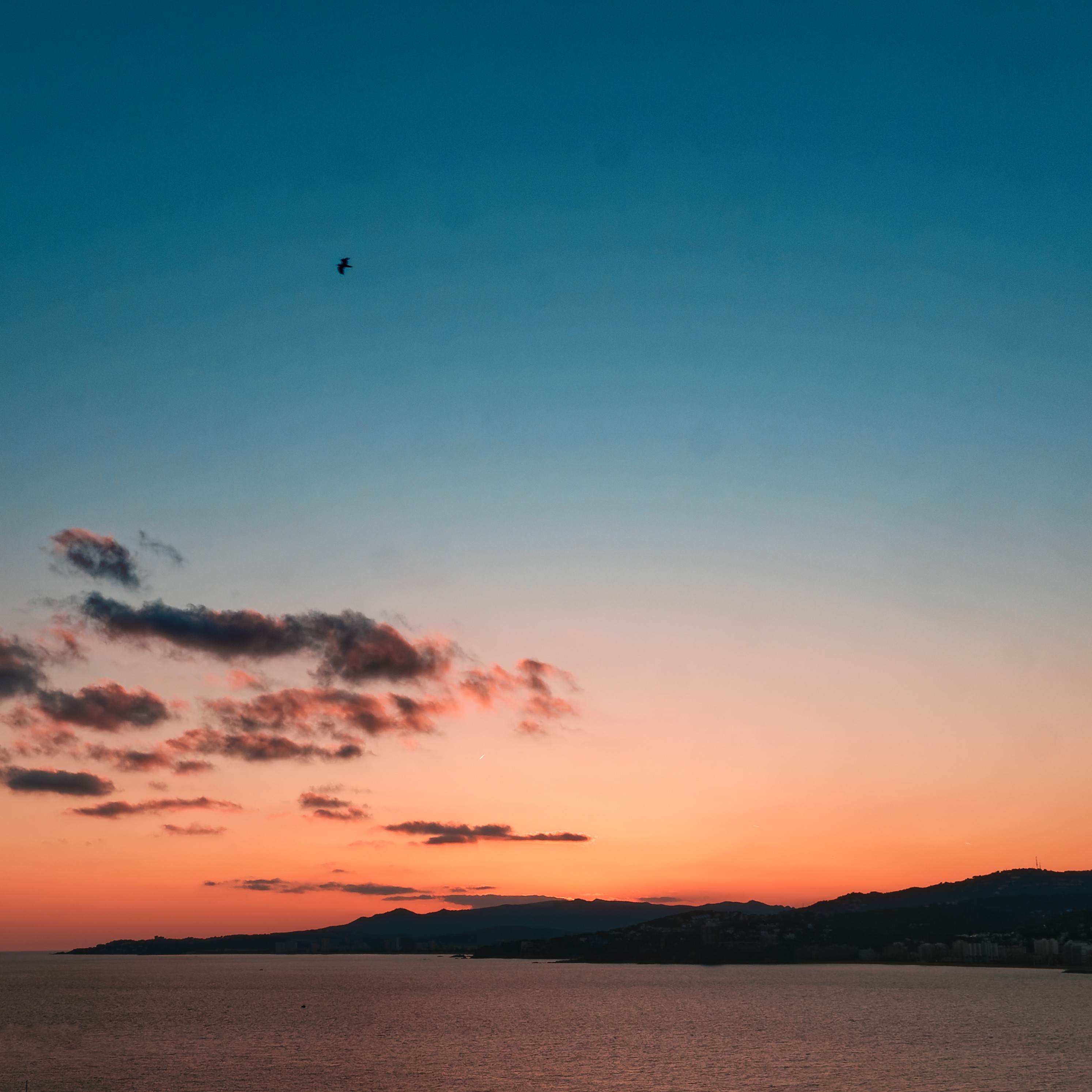 Ciel et mer à l'heure où le soleil se couche, avec quelques nuages. Photo prise à Palamos à la toute fin de 2024